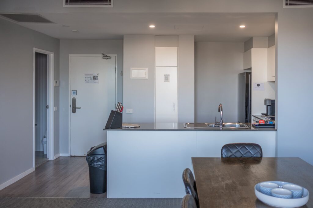 Modern kitchen and dining area in prestige two bedroom room 703 at Honeysuckle Apartments Newcastle.