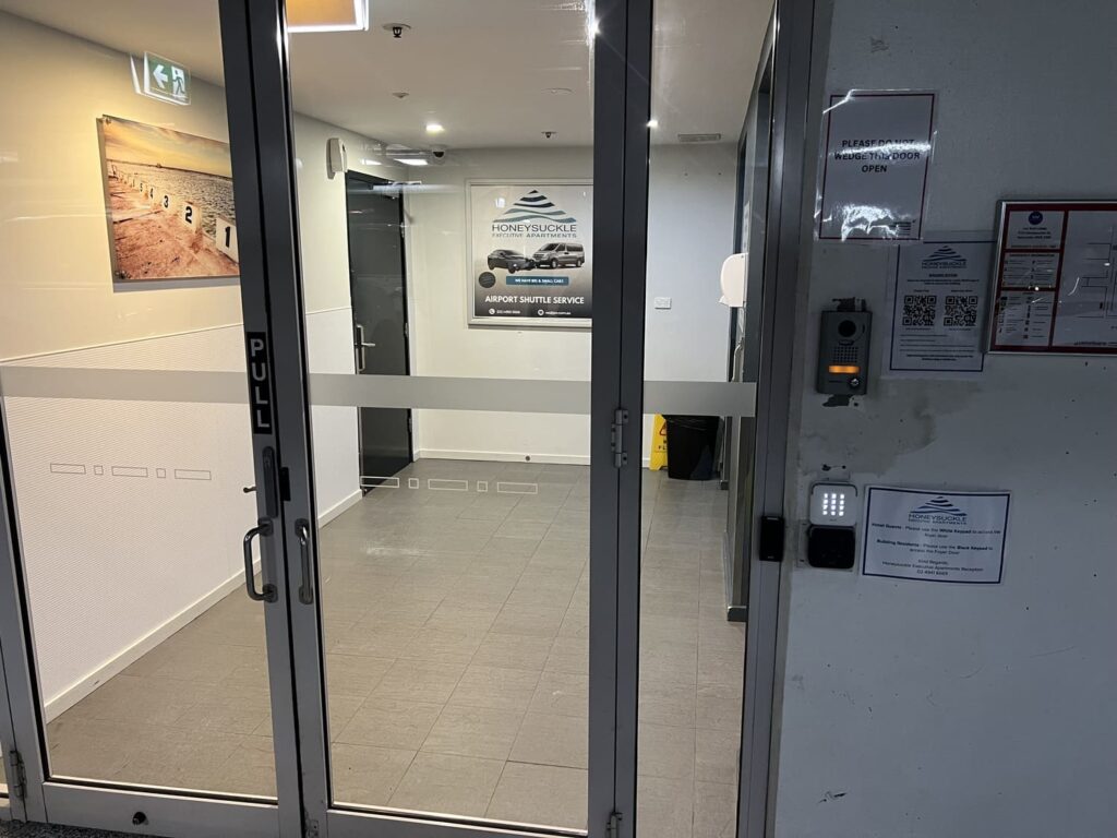 Secure entry foyer to Honeysuckle Executive Apartments with signage and intercom from carpark level