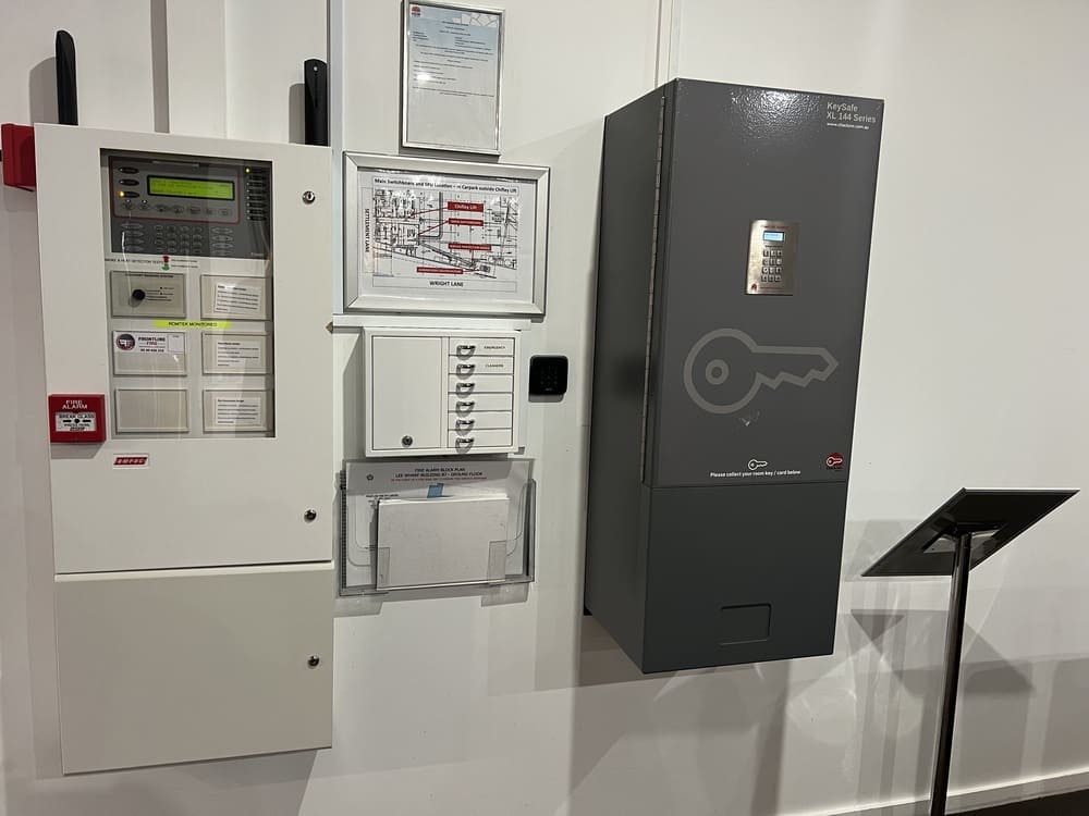 Fire alarm panel and secure key cabinet at Honeysuckle Executive Apartments emergency control room wall
