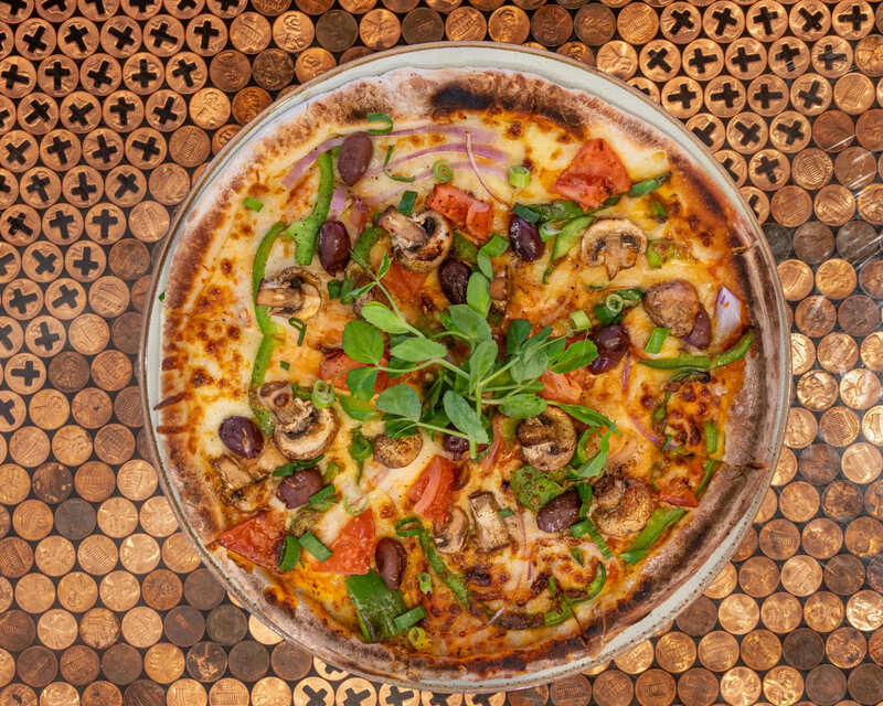 Mediterranean pizza with olives and vegetables at Moneypenny Newcastle near Honeysuckle Apartments.