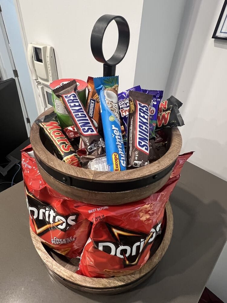 Snack basket at Honeysuckle Executive Apartments with chips, chocolate bars and sweet treats