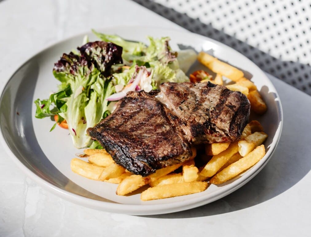Grilled steak with chips and salad at The Dockyard near Honeysuckle Apartments.
